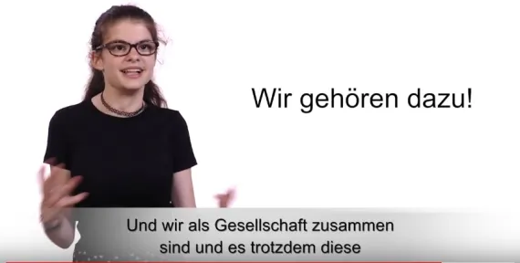 Junge Frau sagt wir gehören dazu! Screenshot aus dem Video der ACHSe Gemeinsam stark.